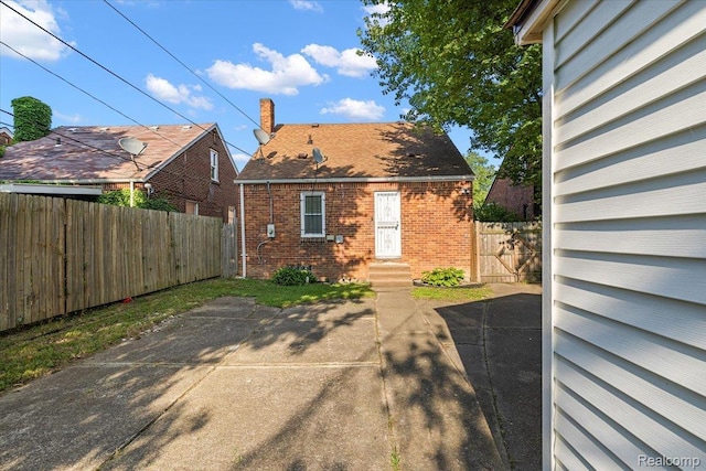 18285 Faust Ave, Detroit, MI 48219 - rear view of house with brick siding, a chimney, a patio area, and entry steps