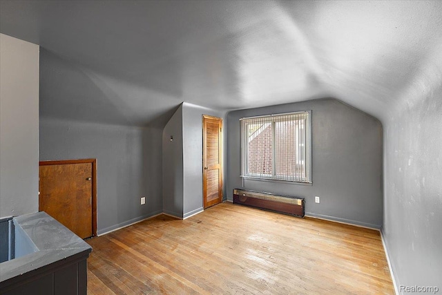 18285 Faust Ave, Detroit, MI 48219 - additional living space with vaulted ceiling, wood finished floors, and a baseboard radiator