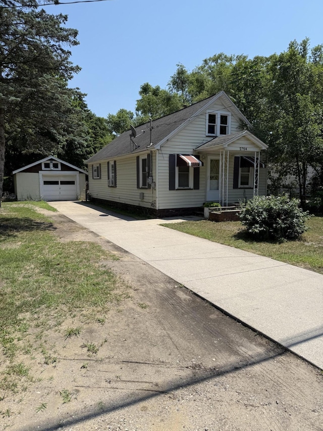 2754 Huizenga St, Norton Shores, MI 49444 - view of front of property featuring concrete driveway, an outbuilding, a garage, and a front yard