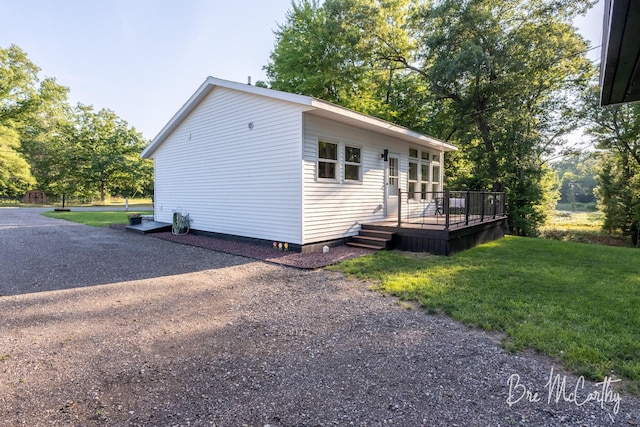 68 E River Rd, Muskegon, MI 49445 - view of side of property featuring a deck and a lawn