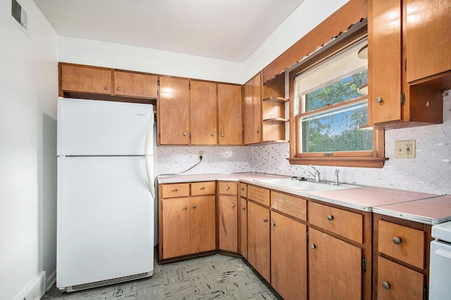 157 Elvern Dr, Coloma, MI 49038 - kitchen with freestanding refrigerator, backsplash, light countertops, open shelves, and brown cabinetry