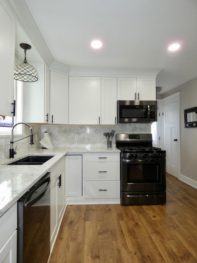 630 Forest St, Wyandotte, MI 48192 - kitchen with stainless steel appliances, light stone countertops, white cabinetry, decorative backsplash, and recessed lighting