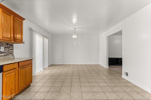 1625 Ferney St, Dearborn Heights, MI 48120 - kitchen with tasteful backsplash, brown cabinetry, light tile patterned floors, and dishwasher