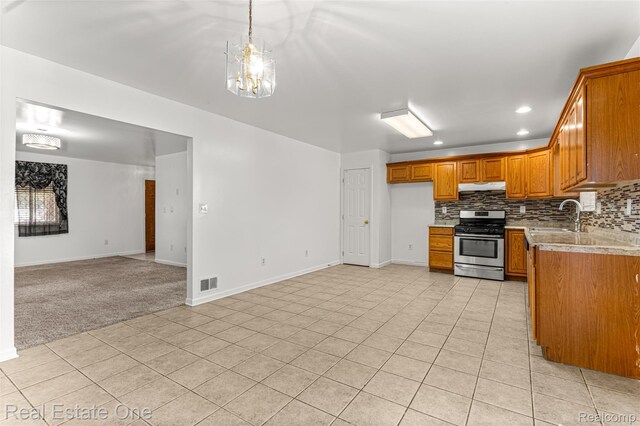 1625 Ferney St, Dearborn Heights, MI 48120 - kitchen featuring stainless steel gas stove, under cabinet range hood, brown cabinetry, recessed lighting, and backsplash