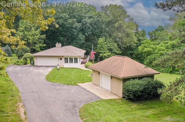 5074 Perryville Rd, Holly, MI 48442 - ranch-style house featuring a detached garage, a front lawn, an outdoor structure, and a chimney