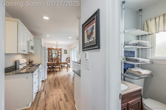5074 Perryville Rd, Holly, MI 48442 - hall featuring a chandelier, light wood-type flooring, plenty of natural light, and recessed lighting