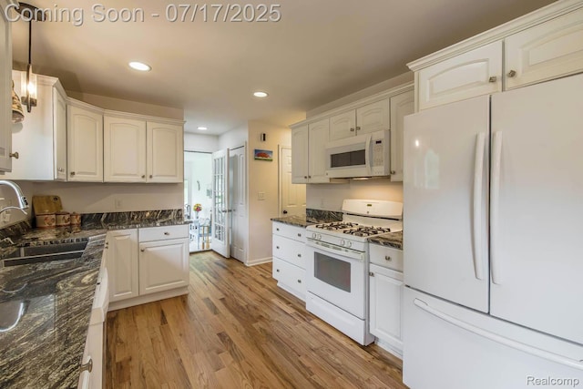5074 Perryville Rd, Holly, MI 48442 - kitchen with white appliances, light wood-style floors, white cabinetry, recessed lighting, and hanging light fixtures