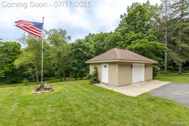 5074 Perryville Rd, Holly, MI 48442 - view of green lawn with a detached garage, an outdoor structure, and driveway