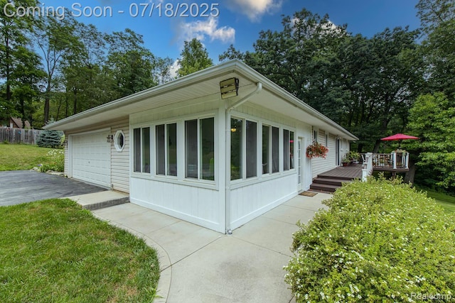 5074 Perryville Rd, Holly, MI 48442 - view of home's exterior featuring a deck, a detached garage, and a lawn