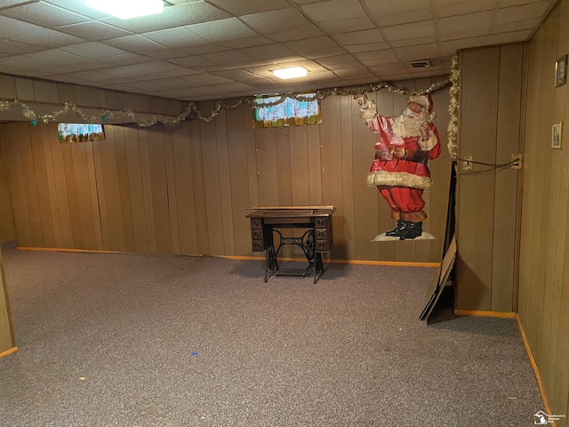 3897 15th St, Wyandotte, MI 48192 - finished basement with carpet flooring, a drop ceiling, a wood stove, and wood walls