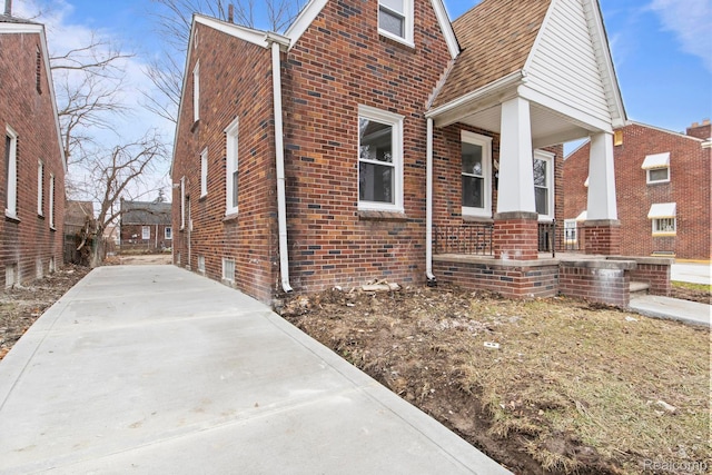 8131 Coyle St, Detroit, MI 48228 - view of side of home featuring brick siding, covered porch, and concrete driveway