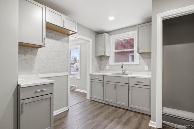 8131 Coyle St, Detroit, MI 48228 - kitchen featuring gray cabinetry, backsplash, dark wood finished floors, healthy amount of natural light, and recessed lighting