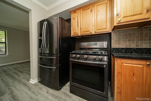 3911 Thomas Ave, Berkley, MI 48072 - kitchen featuring stainless steel range with gas cooktop, black fridge, crown molding, light wood finished floors, and backsplash