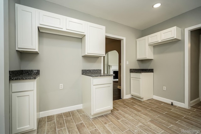 17344 Wisconsin St, Detroit, MI 48221 - kitchen featuring light wood finished floors, white cabinetry, dark stone countertops, and recessed lighting