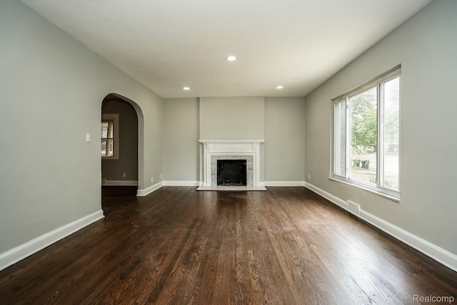 17344 Wisconsin St, Detroit, MI 48221 - unfurnished living room featuring wood finished floors, arched walkways, a fireplace with flush hearth, and recessed lighting