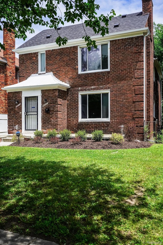 17344 Wisconsin St, Detroit, MI 48221 - view of front of house featuring a front lawn, brick siding, a chimney, and a shingled roof