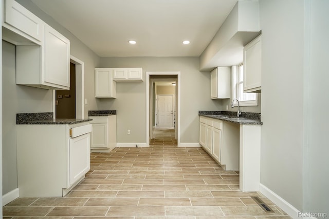 17344 Wisconsin St, Detroit, MI 48221 - kitchen with dark stone counters, white cabinets, recessed lighting, and light wood-style floors
