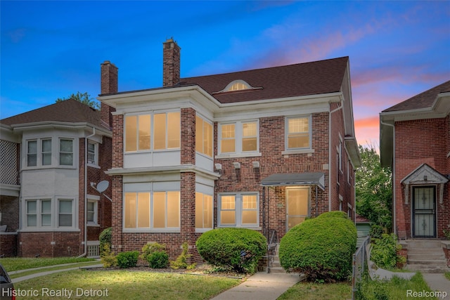 1536 Glynn Ct, Detroit, MI 48206 - view of front of home with brick siding, a chimney, and a front yard