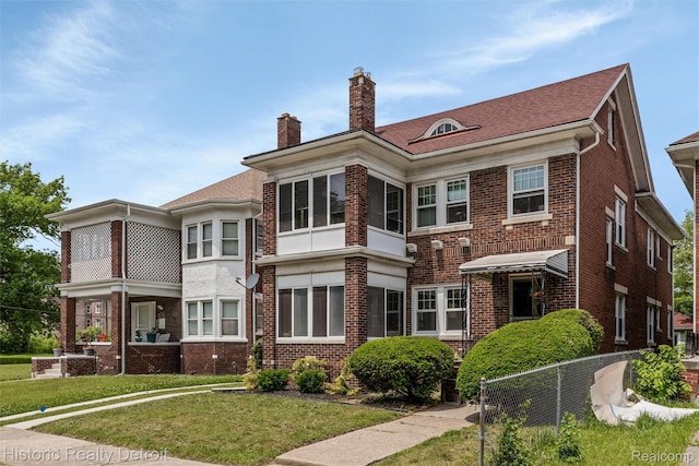 1536 Glynn Ct, Detroit, MI 48206 - rear view of house featuring brick siding, a chimney, and a lawn