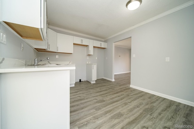 967 Keith St, Oxford, MI 48371 - kitchen featuring crown molding, light wood finished floors, white cabinetry, and light countertops