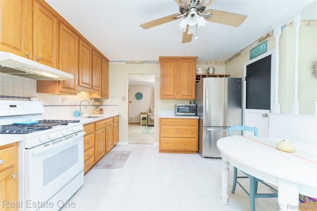 5320 Leland St, Brighton, MI 48116 - kitchen with appliances with stainless steel finishes, under cabinet range hood, light countertops, ceiling fan, and light floors