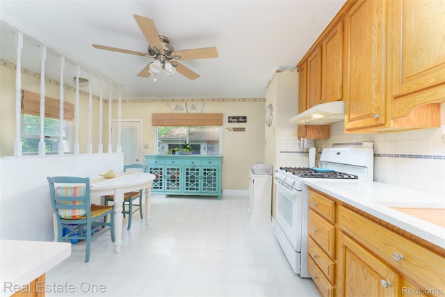 5320 Leland St, Brighton, MI 48116 - kitchen featuring white range with gas stovetop, under cabinet range hood, ceiling fan, light flooring, and light countertops