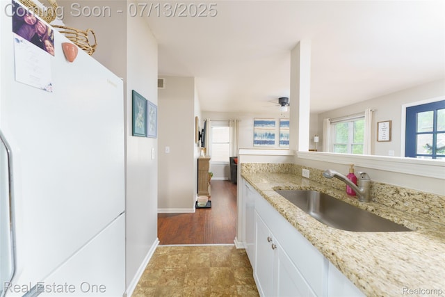 421 Montclair Ln, Howell, MI 48843 - kitchen featuring freestanding refrigerator, white cabinetry, light stone countertops, and ceiling fan