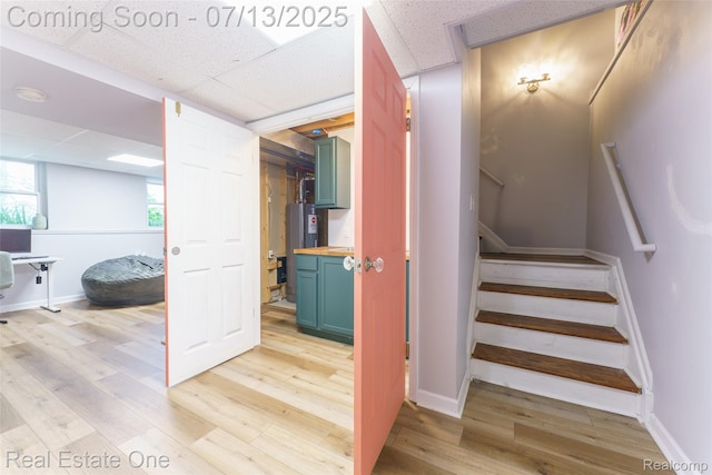 421 Montclair Ln, Howell, MI 48843 - stairs with a paneled ceiling, wood finished floors, and water heater