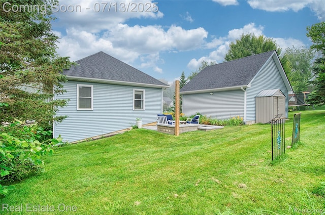 421 Montclair Ln, Howell, MI 48843 - back of house with a storage unit, a yard, and a shingled roof