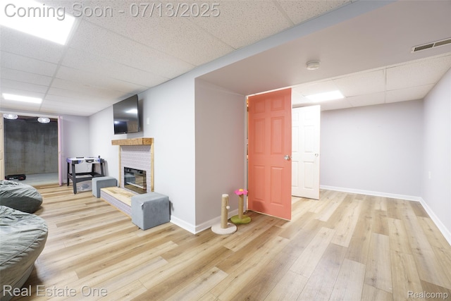 421 Montclair Ln, Howell, MI 48843 - living room featuring a drop ceiling, wood finished floors, and a brick fireplace