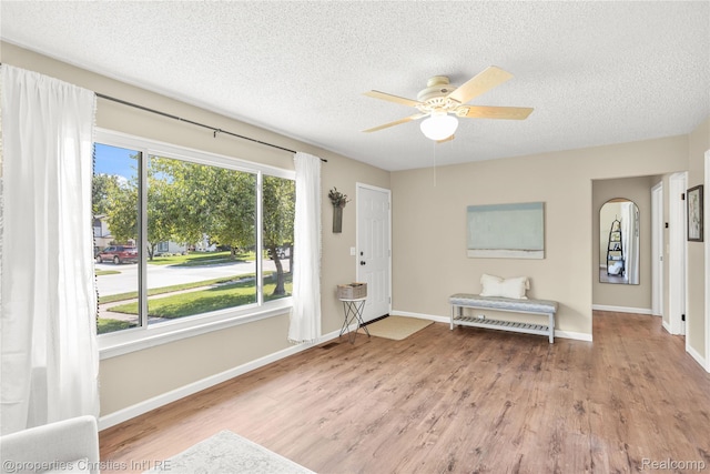 61374 Dean Dr, South Lyon, MI 48178 - foyer featuring a textured ceiling, a ceiling fan, wood finished floors, and arched walkways