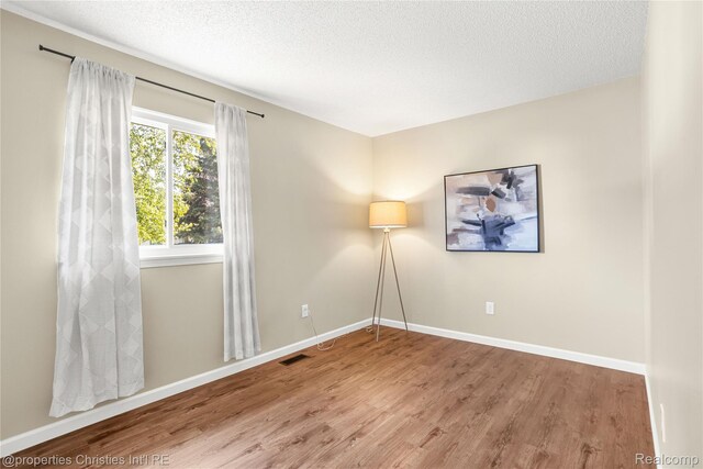 61374 Dean Dr, South Lyon, MI 48178 - empty room featuring wood finished floors and a textured ceiling