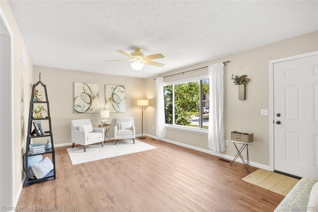 61374 Dean Dr, South Lyon, MI 48178 - living area featuring a ceiling fan, wood finished floors, and a textured ceiling
