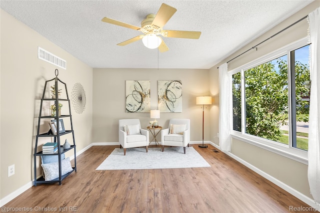 61374 Dean Dr, South Lyon, MI 48178 - living area featuring a textured ceiling, wood finished floors, and a ceiling fan