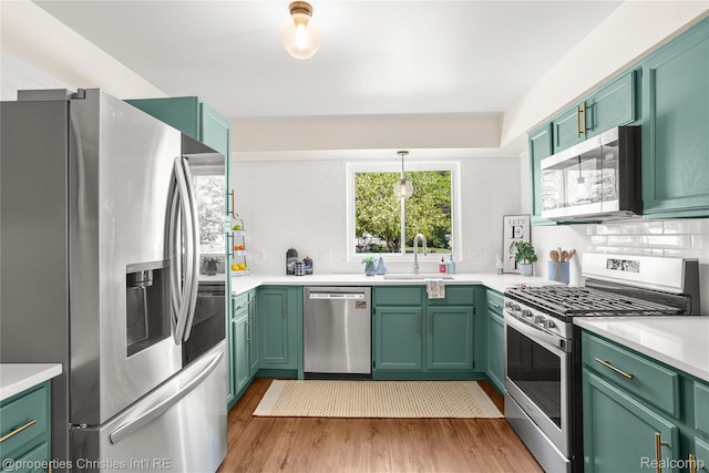 61374 Dean Dr, South Lyon, MI 48178 - kitchen with stainless steel appliances, green cabinets, wood finished floors, and light countertops