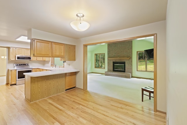 7184 Steeplechase Dr, Saline, MI 48176 - kitchen featuring range with electric cooktop, light brown cabinets, a peninsula, light wood-style flooring, and open floor plan