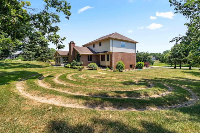 7184 Steeplechase Dr, Saline, MI 48176 - back of house featuring brick siding, a chimney, and a lawn