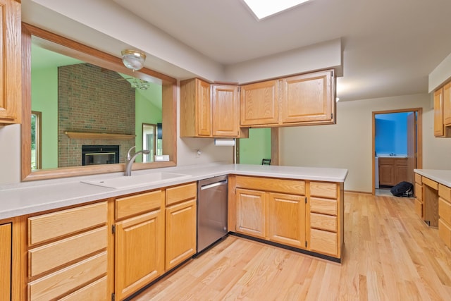 7184 Steeplechase Dr, Saline, MI 48176 - kitchen with dishwasher, light countertops, light wood-style flooring, a peninsula, and a fireplace