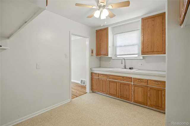 14888 Belmont Ave, Southgate, MI 48101 - kitchen with a ceiling fan, brown cabinetry, light countertops, and light floors