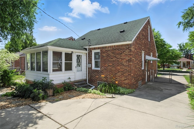 14888 Belmont Ave, Southgate, MI 48101 - back of property featuring a shingled roof, entry steps, brick siding, driveway, and a gate