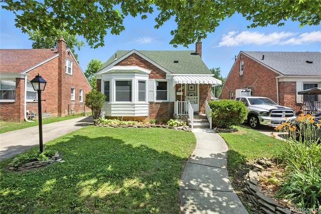 14888 Belmont Ave, Southgate, MI 48101 - bungalow featuring a front yard, brick siding, a shingled roof, and a chimney