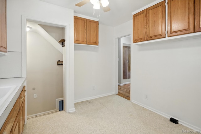 14888 Belmont Ave, Southgate, MI 48101 - kitchen with light colored carpet, ceiling fan, brown cabinetry, and light countertops