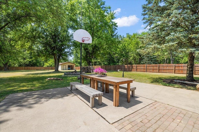 9950 Carpenter Rd, Milan, MI 48160 - fenced backyard featuring an outdoor structure, a patio area, outdoor dining space, and view of wooded area