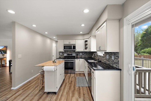 9950 Carpenter Rd, Milan, MI 48160 - kitchen with appliances with stainless steel finishes, backsplash, light wood-type flooring, white cabinets, and recessed lighting