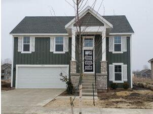 7457 Traditional Ct, Caledonia, MI 49316 - view of front of home featuring board and batten siding, concrete driveway, and an attached garage