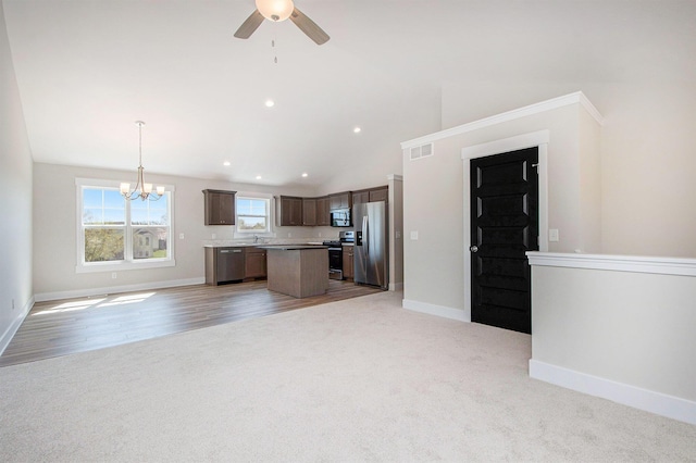 7457 Traditional Ct, Caledonia, MI 49316 - kitchen with appliances with stainless steel finishes, open floor plan, light colored carpet, a center island, and ceiling fan