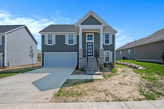 7457 Traditional Ct, Caledonia, MI 49316 - view of front of house featuring a garage, board and batten siding, driveway, and stone siding