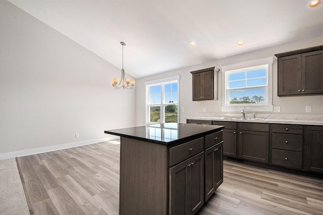 7457 Traditional Ct, Caledonia, MI 49316 - kitchen with vaulted ceiling, a chandelier, recessed lighting, light wood-style floors, and a center island