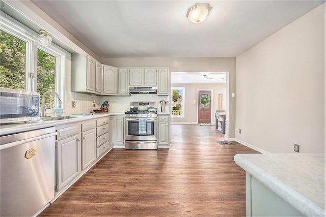 416 Kent St, Lowell, MI 49331 - kitchen with appliances with stainless steel finishes, extractor fan, dark wood-type flooring, light countertops, and backsplash
