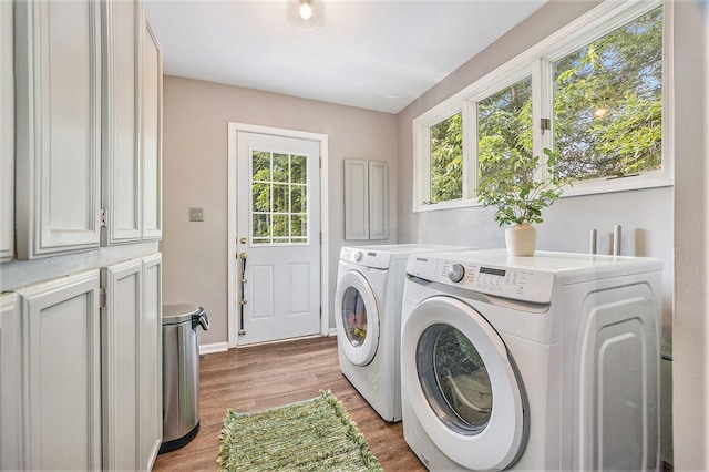 416 Kent St, Lowell, MI 49331 - laundry area with washing machine and clothes dryer, cabinet space, plenty of natural light, and light wood-style floors